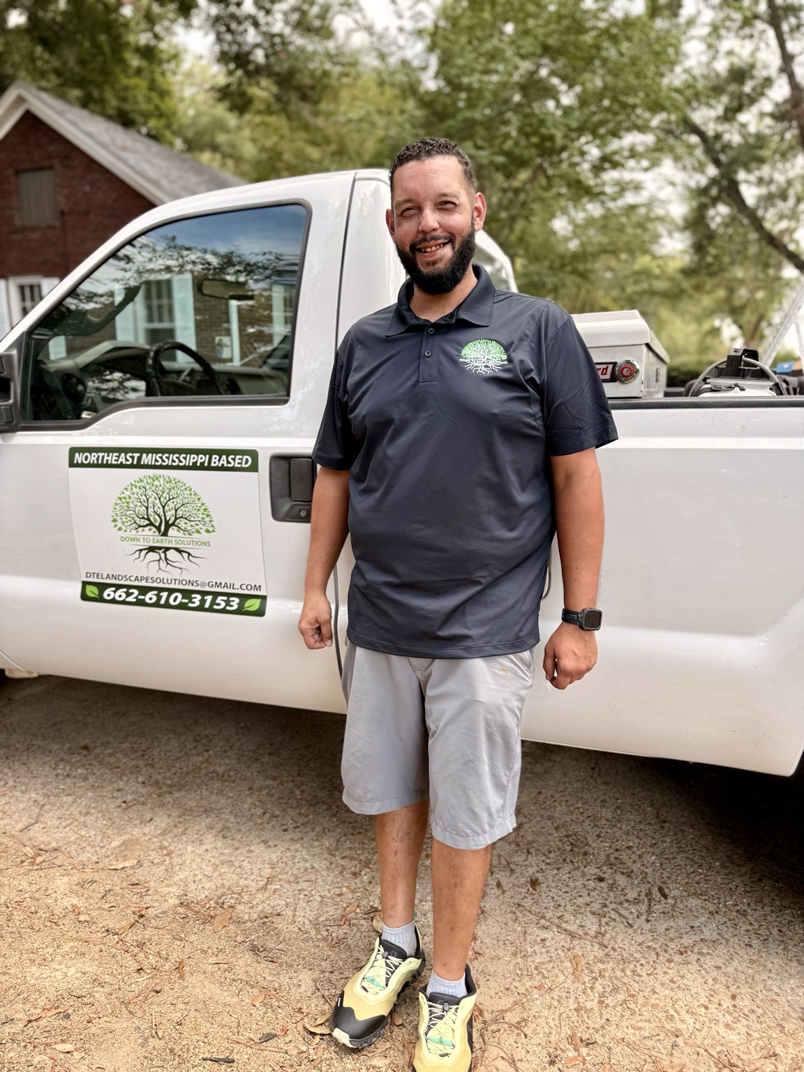 Andrew from Down To Earth Solutions beside the company’s branded work truck.